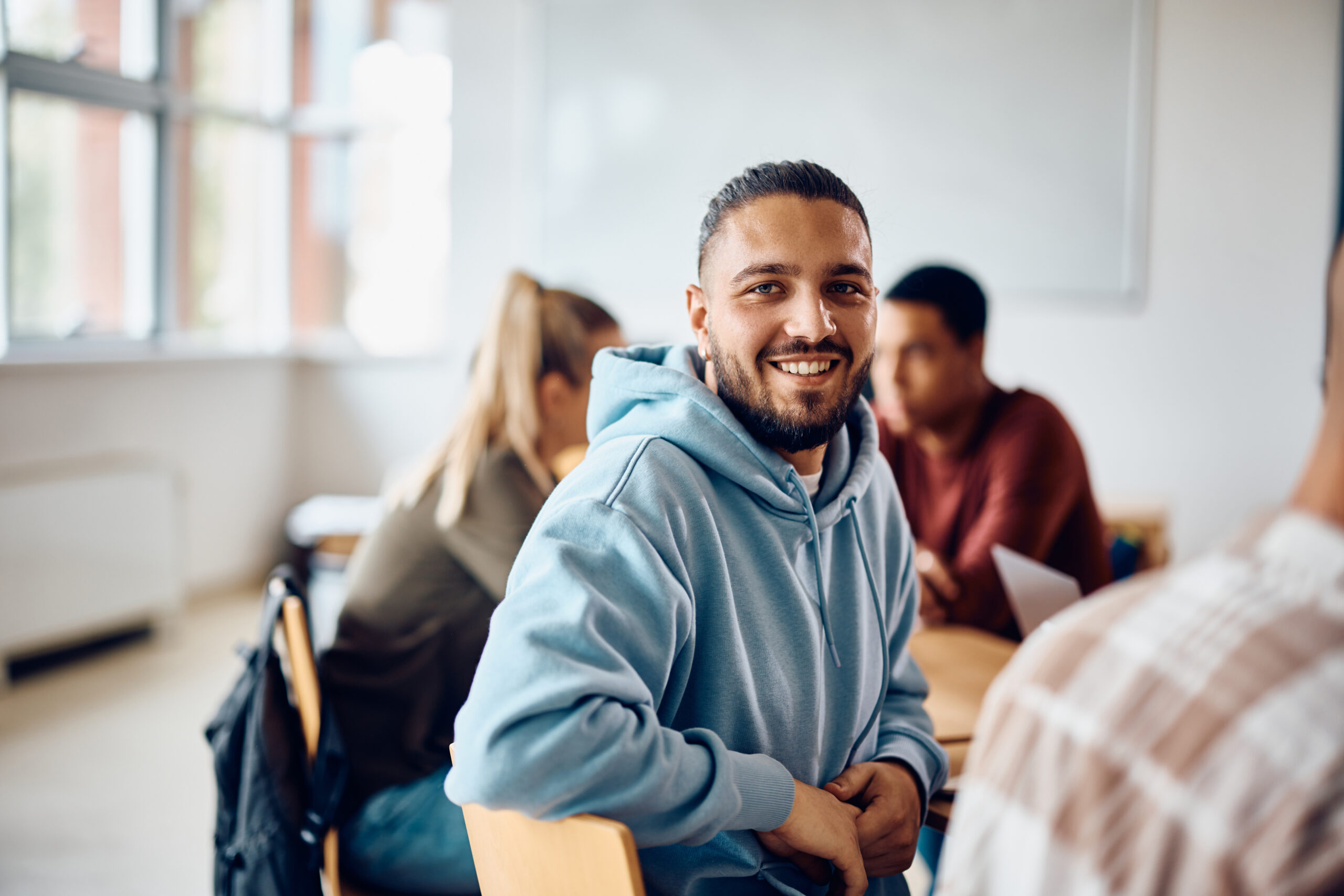 Personas en clase, una mirando a cámara